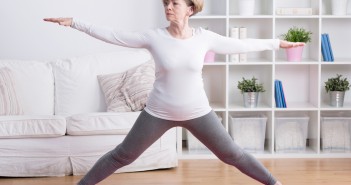 Healthy middle aged woman training yoga at home