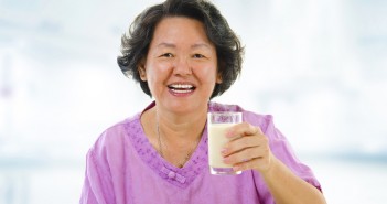 Senior Asian woman holding a glass of soy milk at home